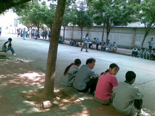 Workers resting outside the Kuan Ho Sporting Goods factory, an adidas supplier where on average workers put in 80 overtime hours per month. (November 2007)